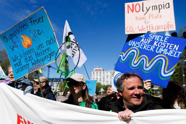 22 April 2026, Berlin: People protest with various banners against the planned bid for the Olympic Games in Berlin. The NOlympia Berlin alliance officially begins collecting signatures for the referendum "For Berlin - against the Olympics. We say no to a bid for the Olympic Games in 2036, 2040 and 2044!". The first signatures against the Olympic Games in Berlin will be collected symbolically in front of the Rotes Rathaus with a colorful action picture and speeches. Photo: Carsten Koall/dpa