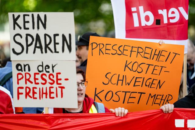 22 April 2026, Berlin: People carry signs during a demonstration by the Deutsche Welle action alliance in Berlin. The motto of the demonstration is "Strengthen Deutsche Welle! For dialog and media freedom - worldwide!". Photo: Fabian Sommer/dpa