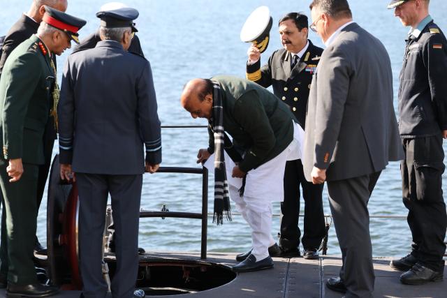 22 April 2026, Schleswig-Holstein, Kiel: Rajnath Singh (C), India's Defence Minister, stumbles while descending a ladder at submarine manufacturer Thyssenkrupp Marine Systems (TKMS) and is helped up by bystanders during a visit with Germany's Defence Minister Boris Pistorius. Photo: Christian Charisius/dpa