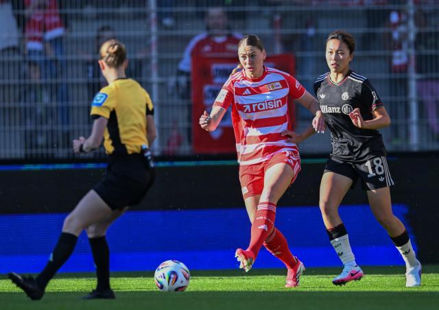 22 April 2026, Berlin: Union Berlin's Samantha Steuerwald (C) and Bayern Munich's Momoko Tanikawa battle for the ball during the German Women's Bundesliga soccer match between 1. FC Union Berlin and Bayern Munich at the Old Forester's House Stadium. Photo: Soeren Stache/dpa - WICHTIGER HINWEIS: Gemäß den Vorgaben der DFL Deutsche Fußball Liga bzw. des DFB Deutscher Fußball-Bund ist es untersagt, in dem Stadion und/oder vom Spiel angefertigte Fotoaufnahmen in Form von Sequenzbildern und/oder videoähnlichen Fotostrecken zu verwerten bzw. verwerten zu lassen.