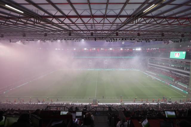 22 April 2026, North Rhine-Westphalia, Leverkusen: Bayer Leverkusen and Bayern Munich players stand amid thick smoke from pyrotechnics during the German DFB Cup semifinal soccer match between Bayer Leverkusen and Bayern Munich at BayArena. Photo: Rolf Vennenbernd/dpa - IMPORTANT NOTICE: DFL and DFB regulations prohibit any use of photographs as image sequences and/or quasi-video.