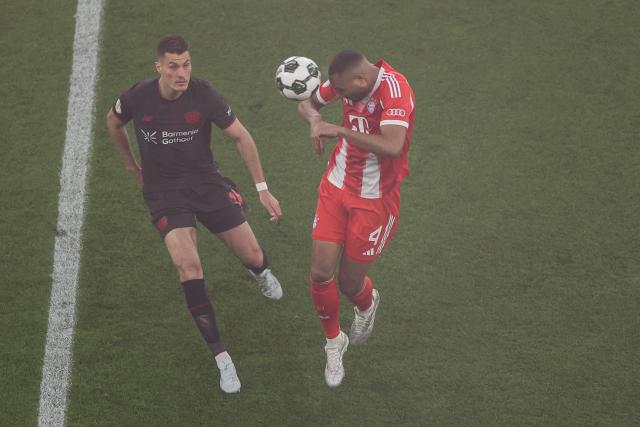 22 April 2026, North Rhine-Westphalia, Leverkusen: Bayer Leverkusen's Patrik Schick (L) and Bayern Munich's Jonathan Tah battle for the ball during the German DFB Cup semifinal soccer match between Bayer Leverkusen and Bayern Munich at BayArena. Photo: Rolf Vennenbernd/dpa - IMPORTANT NOTICE: DFL and DFB regulations prohibit any use of photographs as image sequences and/or quasi-video.