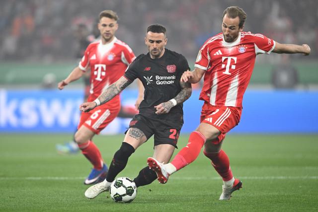 22 April 2026, North Rhine-Westphalia, Leverkusen: Bayer Leverkusen's Aleix Garcia and Bayern Munich's Harry Kane (R) battle for the ball during the German DFB Cup semifinal soccer match between Bayer Leverkusen and Bayern Munich at BayArena. Photo: Federico Gambarini/dpa - IMPORTANT NOTICE: DFL and DFB regulations prohibit any use of photographs as image sequences and/or quasi-video.