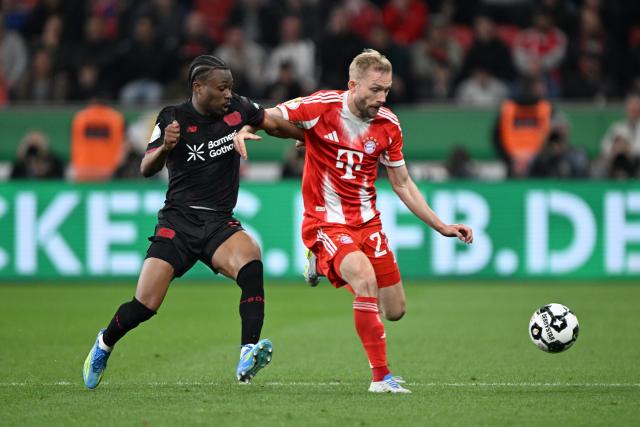 22 April 2026, North Rhine-Westphalia, Leverkusen: Bayer Leverkusen's Nathan Tella (L) and Bayern Munich's Konrad Laimer battle for the ball during the German DFB Cup semifinal soccer match between Bayer Leverkusen and Bayern Munich at BayArena. Photo: Federico Gambarini/dpa - IMPORTANT NOTICE: DFL and DFB regulations prohibit any use of photographs as image sequences and/or quasi-video.