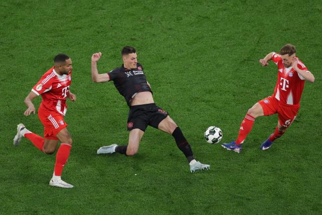 22 April 2026, North Rhine-Westphalia, Leverkusen: Bayer Leverkusen's Patrik Schick (C) battles for the ball with Bayern Munich's Jonathan Tah (L) and Joshua Kimmich during the German DFB Cup semifinal soccer match between Bayer Leverkusen and Bayern Munich at BayArena. Photo: Rolf Vennenbernd/dpa - IMPORTANT NOTICE: DFL and DFB regulations prohibit any use of photographs as image sequences and/or quasi-video.