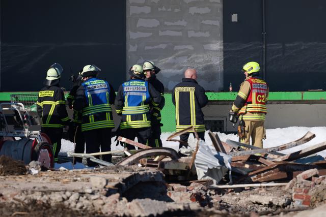 23 April 2026, North Rhine-Westphalia, Dortmund: Firefighters are seen in front of a badly damaged building after a fire in the city center. A fire has broken out in a vacant building in Dortmund. According to the fire department, a large contingent has been working for several hours. The fire was reported at around 9.30 p.m., according to reports. As the entire roof was on fire, the fire department was unable to enter the building. The extinguishing work therefore moved outside. According to the fire department, parts of the roof collapsed as a result. Photo: Bernd Thissen/dpa