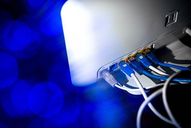 ILLUSTRATION - Zahlreiche Netzwerkkabel (LAN-Kabel) stecken in einem Router. Die Bundesregierung veröffentlicht den Fortschrittsbericht zum Ausbau von Glasfaser- und 5G-Netzen.