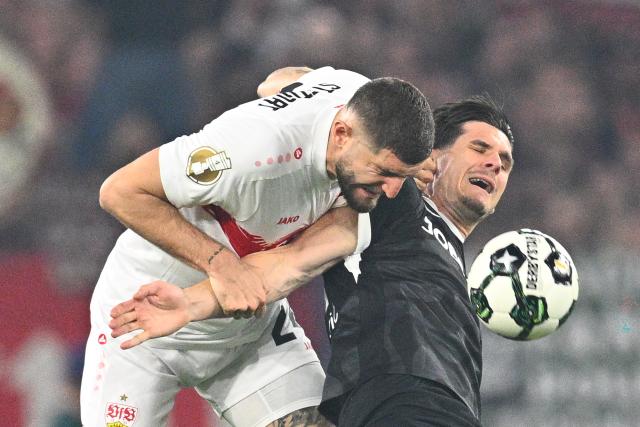 23 April 2026, Baden-Wuerttemberg, Stuttgart: Stuttgart's Jeff Chabot and Freiburg's Igor Matanovic (R) battle for the ball during the German DFB Cup semifinal soccer match between VfB Stuttgart and SC Freiburg at MHPArena. Photo: Tom Weller/dpa - IMPORTANT NOTICE: DFL and DFB regulations prohibit any use of photographs as image sequences and/or quasi-video.