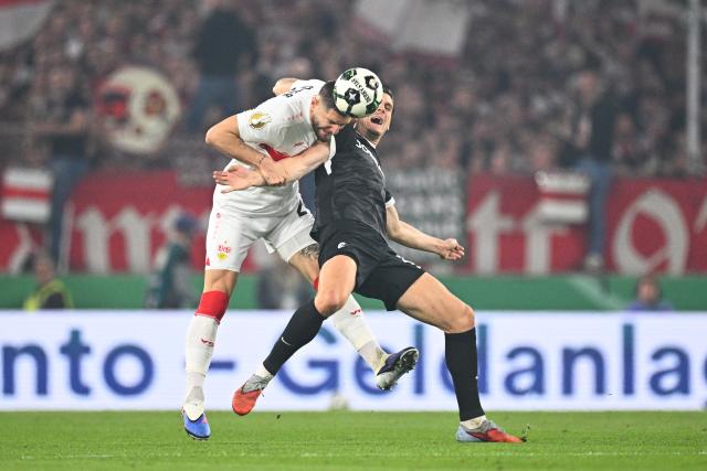 23 April 2026, Baden-Wuerttemberg, Stuttgart: Stuttgart's Jeff Chabot and Freiburg's Igor Matanovic (R) battle for the ball during the German DFB Cup semifinal soccer match between VfB Stuttgart and SC Freiburg at MHPArena. Photo: Tom Weller/dpa - IMPORTANT NOTICE: DFL and DFB regulations prohibit any use of photographs as image sequences and/or quasi-video.