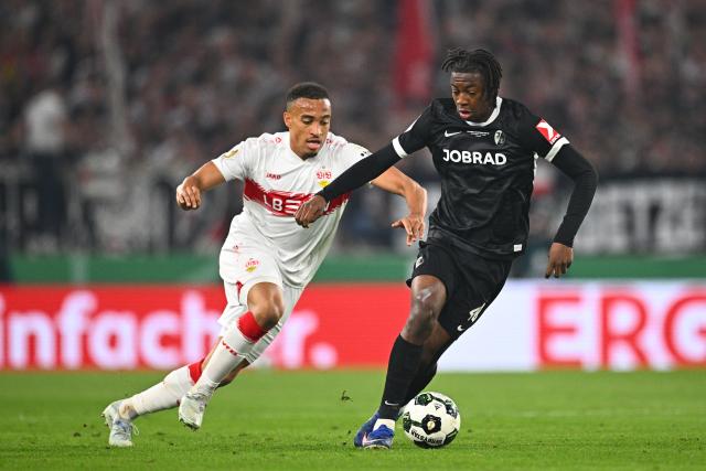 23 April 2026, Baden-Wuerttemberg, Stuttgart: Stuttgart's Jamie Leweling and Freiburg's Johan Manzambi (R) battle for the ball during the German DFB Cup semifinal soccer match between VfB Stuttgart and SC Freiburg at MHPArena. Photo: Tom Weller/dpa - IMPORTANT NOTICE: DFL and DFB regulations prohibit any use of photographs as image sequences and/or quasi-video.