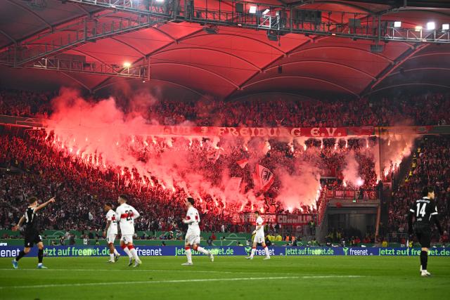 23 April 2026, Baden-Wuerttemberg, Stuttgart: Freiburg fans set off pyrotechnics during the German DFB Cup semifinal soccer match between VfB Stuttgart and SC Freiburg at MHPArena. Photo: Tom Weller/dpa - IMPORTANT NOTICE: DFL and DFB regulations prohibit any use of photographs as image sequences and/or quasi-video.