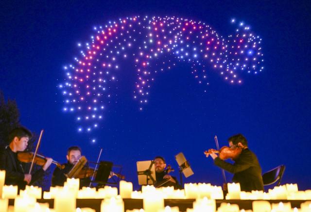 23 April 2026, Berlin: Synchronized drones display light patterns in the sky above the Gardens of the World during a DroneArt show, accompanied by a live string quartet as up to 1,000 drones form shapes in the night sky. Photo: Jens Kalaene/dpa