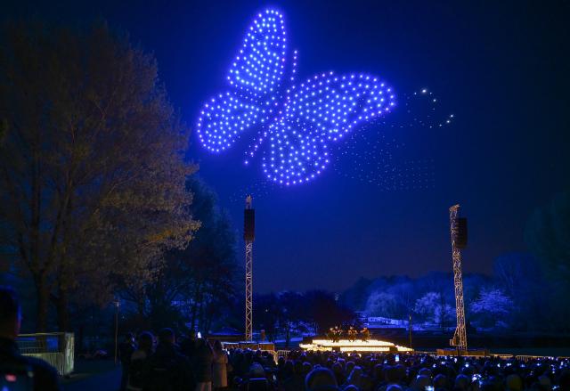 23 April 2026, Berlin: Synchronized drones display light patterns in the sky above the Gardens of the World during a DroneArt show, accompanied by a live string quartet as up to 1,000 drones form shapes in the night sky. Photo: Jens Kalaene/dpa