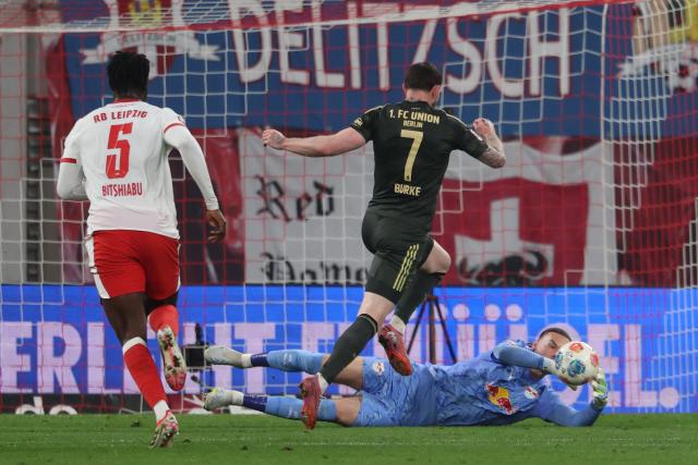 24 April 2026, Saxony, Leipzig: Leipzig goalkeeper Maarten Vandevoordt catches the ball alongside Leipzig's El Chadaille Bitshiabu and Union Berlin's Oliver Burke during the German Bundesliga soccer match between RB Leipzig and 1. FC Union Berlin at Red Bull Arena. Photo: Jan Woitas/dpa - IMPORTANT NOTICE: DFL and DFB regulations prohibit any use of photographs as image sequences and/or quasi-video.