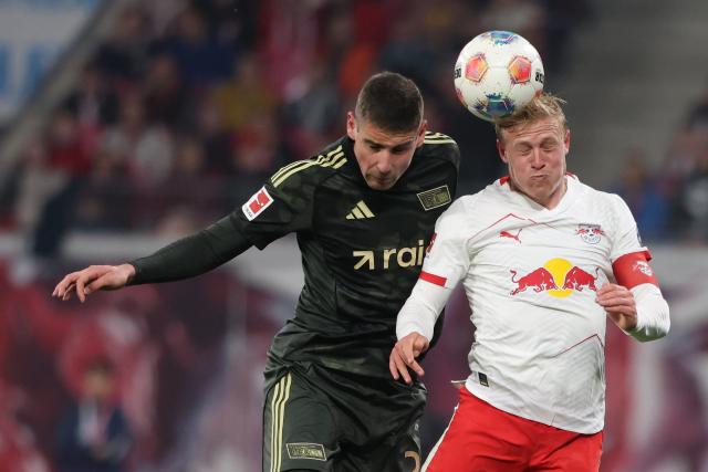 24 April 2026, Saxony, Leipzig: Leipzig's Xaver Schlager (R) and Union Berlin's Andrej Ilic in a header duel during the German Bundesliga soccer match between RB Leipzig and 1. FC Union Berlin at Red Bull Arena. Photo: Jan Woitas/dpa - IMPORTANT NOTICE: DFL and DFB regulations prohibit any use of photographs as image sequences and/or quasi-video.