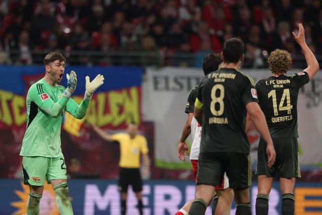 24 April 2026, Saxony, Leipzig: (L-R) Union Berlin goalkeeper Carl Klaus celebrates with Union Berlin's Rani Khedira and Union Berlin's Leopold Querfeld after scoring his side's first goal of the game during the German Bundesliga soccer match between RB Leipzig and 1. FC Union Berlin at Red Bull Arena. Photo: Jan Woitas/dpa - IMPORTANT NOTICE: DFL and DFB regulations prohibit any use of photographs as image sequences and/or quasi-video.