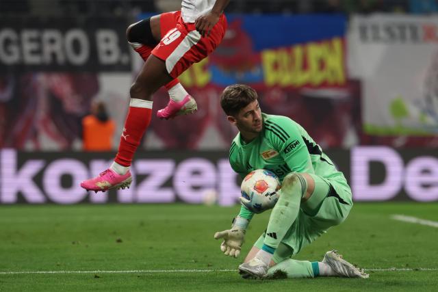 24 April 2026, Saxony, Leipzig: Leipzig's Yan Diomande jumps over Union Berlin goalkeeper Carl Klaus during the German Bundesliga soccer match between RB Leipzig and 1. FC Union Berlin at Red Bull Arena. Photo: Jan Woitas/dpa - IMPORTANT NOTICE: DFL and DFB regulations prohibit any use of photographs as image sequences and/or quasi-video.
