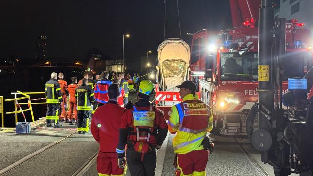 25 April 2026, Frankfurt_Main: A vehicle is being lifted out of a harbor basin on the Main River. Two youths are in a critical condition after a car carrying five youngsters aged 17 and 18 plunged 8 metres into the River Main overnight, Frankfurt police and fire services reported on Saturday. Photo: Mike Seeboth/dpa