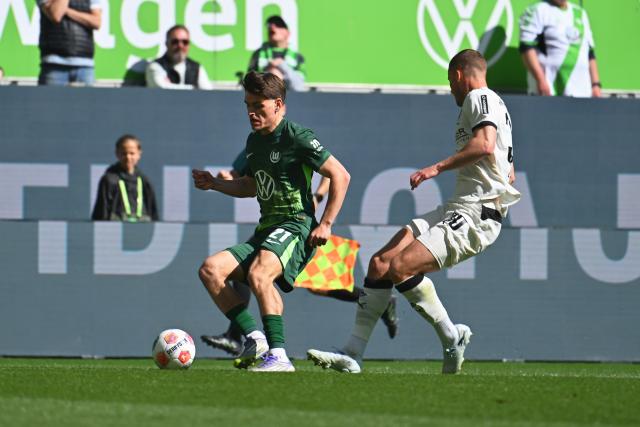 25 April 2026, Lower Saxony, Wolfsburg: Wolfsburg's Joakim Maehle (L) dribbles past Moenchengladbach's Nico Elvedi (R) during the German Bundesliga soccer match between VfL Wolfsburg and Borussia Moenchengladbach at the Volkswagen Arena. Photo: Swen Pförtner/dpa - IMPORTANT NOTE: In accordance with the regulations of the DFL German Football League and the DFB German Football Association, it is prohibited to utilize or have utilized photographs taken in the stadium and/or of the match in the form of sequential images and/or video-like photo series.
