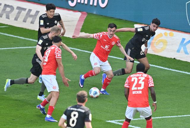 25 April 2026, Rhineland-Palatinate, Mainz: Mainz 's Paul Nebel and Bayern Munich's Josip Stanisic battle for the ball during the German Bundesliga soccer match between FSV Mainz 05 and Bayern Munich at Mewa Arena. Photo: Torsten Silz/dpa - WICHTIGER HINWEIS: Gemäß den Vorgaben der DFL Deutsche Fußball Liga bzw. des DFB Deutscher Fußball-Bund ist es untersagt, in dem Stadion und/oder vom Spiel angefertigte Fotoaufnahmen in Form von Sequenzbildern und/oder videoähnlichen Fotostrecken zu verwerten bzw. verwerten zu lassen.