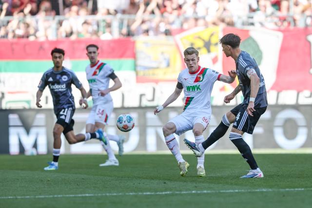 25 April 2026, Bavaria, Augsburg: Frankfurt's Robin Koch (R) and Augsburg's Anton Kade battle for the ball during the German Bundesliga soccer match between FC Augsburg and Eintracht Frankfurt at WWK-Arena. Photo: Daniel Löb/dpa - WICHTIGER HINWEIS: Gemäß den Vorgaben der DFL Deutsche Fußball Liga bzw. des DFB Deutscher Fußball-Bund ist es untersagt, in dem Stadion und/oder vom Spiel angefertigte Fotoaufnahmen in Form von Sequenzbildern und/oder videoähnlichen Fotostrecken zu verwerten bzw. verwerten zu lassen.