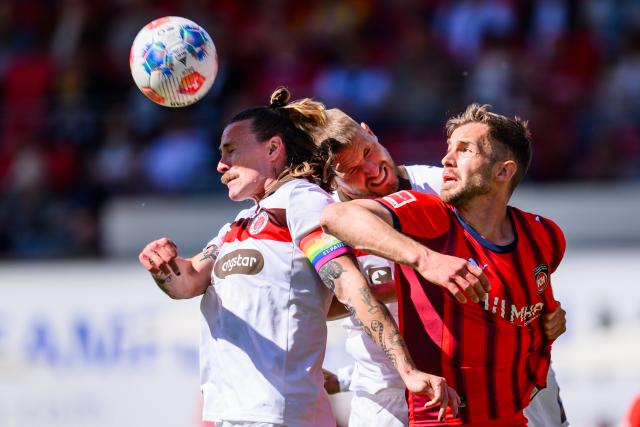 25 April 2026, Baden-Wuerttemberg, Heidenheim: St. Pauli's Jackson Irvine (L) and St. Pauli's Hauke Wahl (C) and Heidenheim's Marvin Pieringer battle for the ball during the German Bundesliga soccer match between 1. FC Heidenheim and FC St. Pauli at Voith-Arena. Photo: Tom Weller/dpa - WICHTIGER HINWEIS: Gemäß den Vorgaben der DFL Deutsche Fußball Liga bzw. des DFB Deutscher Fußball-Bund ist es untersagt, in dem Stadion und/oder vom Spiel angefertigte Fotoaufnahmen in Form von Sequenzbildern und/oder videoähnlichen Fotostrecken zu verwerten bzw. verwerten zu lassen.