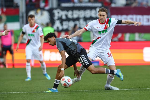 25 April 2026, Bavaria, Augsburg: Augsburg's Arthur Chaves (R) and Frankfurt's Nathaniel Brown battle for the ball during the German Bundesliga soccer match between FC Augsburg and Eintracht Frankfurt at WWK-Arena. Photo: Daniel Löb/dpa - WICHTIGER HINWEIS: Gemäß den Vorgaben der DFL Deutsche Fußball Liga bzw. des DFB Deutscher Fußball-Bund ist es untersagt, in dem Stadion und/oder vom Spiel angefertigte Fotoaufnahmen in Form von Sequenzbildern und/oder videoähnlichen Fotostrecken zu verwerten bzw. verwerten zu lassen.