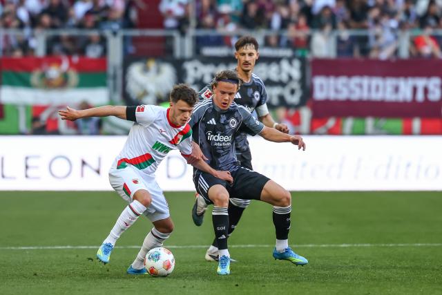 25 April 2026, Bavaria, Augsburg: Augsburg's Robin Fellhauer (L) and Frankfurt's Love Arrhov battle for the ball during the German Bundesliga soccer match between FC Augsburg and Eintracht Frankfurt at WWK-Arena. Photo: Daniel Löb/dpa - WICHTIGER HINWEIS: Gemäß den Vorgaben der DFL Deutsche Fußball Liga bzw. des DFB Deutscher Fußball-Bund ist es untersagt, in dem Stadion und/oder vom Spiel angefertigte Fotoaufnahmen in Form von Sequenzbildern und/oder videoähnlichen Fotostrecken zu verwerten bzw. verwerten zu lassen.