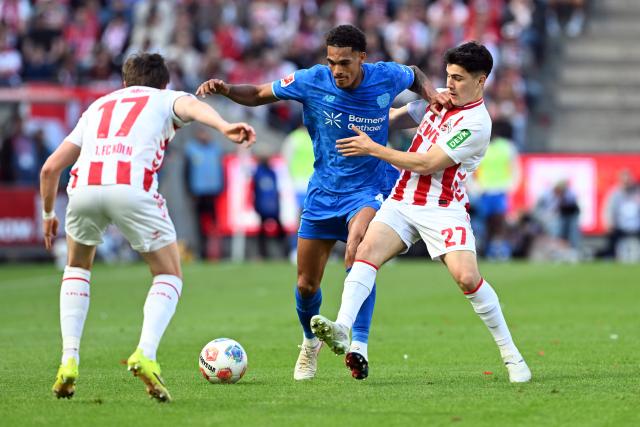 25 April 2026, North Rhine-Westphalia, Cologne: Cologne's Felipe Chavez and Leverkusen's Jarell Quansah battle for the ball during the German Bundesliga soccer match between 1. FC Cologne and Bayer Leverkusen at RheinEnergieSTADION. Photo: Federico Gambarini/dpa - WICHTIGER HINWEIS: Gemäß den Vorgaben der DFL Deutsche Fußball Liga bzw. des DFB Deutscher Fußball-Bund ist es untersagt, in dem Stadion und/oder vom Spiel angefertigte Fotoaufnahmen in Form von Sequenzbildern und/oder videoähnlichen Fotostrecken zu verwerten bzw. verwerten zu lassen.