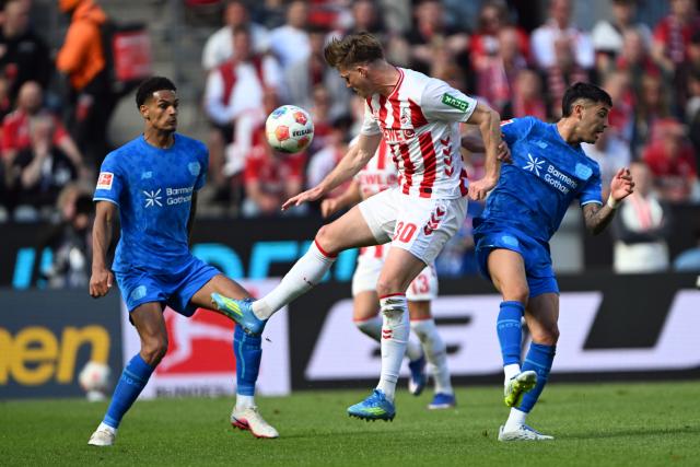 25 April 2026, North Rhine-Westphalia, Cologne: Cologne's Marius Buelter and Leverkusen's Exequiel Palacios battle for the ball during the German Bundesliga soccer match between 1. FC Cologne and Bayer Leverkusen at RheinEnergieSTADION. Photo: Federico Gambarini/dpa - WICHTIGER HINWEIS: Gemäß den Vorgaben der DFL Deutsche Fußball Liga bzw. des DFB Deutscher Fußball-Bund ist es untersagt, in dem Stadion und/oder vom Spiel angefertigte Fotoaufnahmen in Form von Sequenzbildern und/oder videoähnlichen Fotostrecken zu verwerten bzw. verwerten zu lassen.