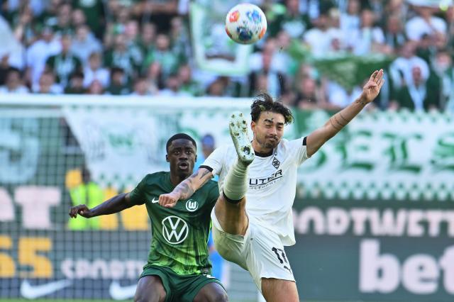 25 April 2026, Lower Saxony, Wolfsburg: Borussia Moenchengladbach's Jens Castrop (R) and Wolfsburg's Saeal Kumbedi (L) battle for the ball during the German Bundesliga soccer match between VfL Wolfsburg and Borussia Moenchengladbach at the Volkswagen Arena. Photo: Swen Pförtner/dpa - IMPORTANT NOTE: In accordance with the regulations of the DFL German Football League and the DFB German Football Association, it is prohibited to utilize or have utilized photographs taken in the stadium and/or of the match in the form of sequential images and/or video-like photo series.