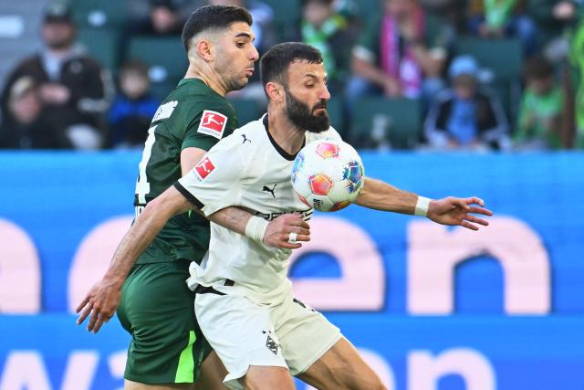 25 April 2026, Lower Saxony, Wolfsburg: Borussia Moenchengladbach's Franck Honorat (R) and Wolfsburg's Konstantinos Koulierakis (L) battle for the ball during the German Bundesliga soccer match between VfL Wolfsburg and Borussia Moenchengladbach at the Volkswagen Arena. Photo: Swen Pförtner/dpa - IMPORTANT NOTE: In accordance with the regulations of the DFL German Football League and the DFB German Football Association, it is prohibited to utilize or have utilized photographs taken in the stadium and/or of the match in the form of sequential images and/or video-like photo series.