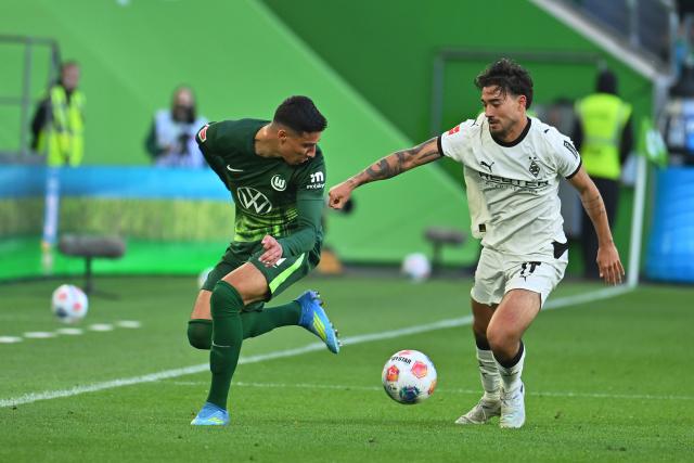 25 April 2026, Lower Saxony, Wolfsburg: Wolfsburg's Adam Daghim (L) and Borussia Moenchengladbach's Jens Castrop (R) battle for the ball during the German Bundesliga soccer match between VfL Wolfsburg and Borussia Moenchengladbach at the Volkswagen Arena. Photo: Swen Pförtner/dpa - IMPORTANT NOTE: In accordance with the regulations of the DFL German Football League and the DFB German Football Association, it is prohibited to utilize or have utilized photographs taken in the stadium and/or of the match in the form of sequential images and/or video-like photo series.
