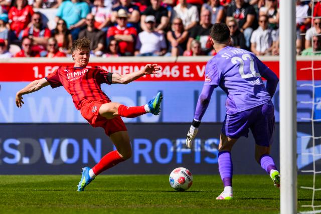 25 April 2026, Baden-Wuerttemberg, Heidenheim: Heidenheim's Jan Schoeppner and St. Pauli goalkeeper Nikola Vasilj battle for the ball during the German Bundesliga soccer match between 1. FC Heidenheim and FC St. Pauli at Voith-Arena. Photo: Tom Weller/dpa - WICHTIGER HINWEIS: Gemäß den Vorgaben der DFL Deutsche Fußball Liga bzw. des DFB Deutscher Fußball-Bund ist es untersagt, in dem Stadion und/oder vom Spiel angefertigte Fotoaufnahmen in Form von Sequenzbildern und/oder videoähnlichen Fotostrecken zu verwerten bzw. verwerten zu lassen.