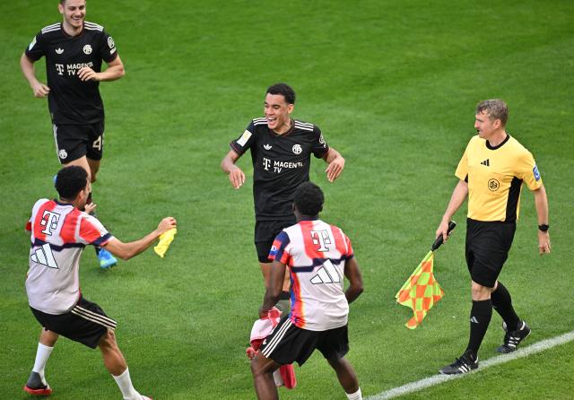 25 April 2026, Rhineland-Palatinate, Mainz: Bayern Munich's Jamal Musiala celebrates with his teammates and the bench after setting up the goal that made his side's fourth goal of the game during the German Bundesliga soccer match between FSV Mainz 05 and Bayern Munich at Mewa Arena. Photo: Torsten Silz/dpa - WICHTIGER HINWEIS: Gemäß den Vorgaben der DFL Deutsche Fußball Liga bzw. des DFB Deutscher Fußball-Bund ist es untersagt, in dem Stadion und/oder vom Spiel angefertigte Fotoaufnahmen in Form von Sequenzbildern und/oder videoähnlichen Fotostrecken zu verwerten bzw. verwerten zu lassen.