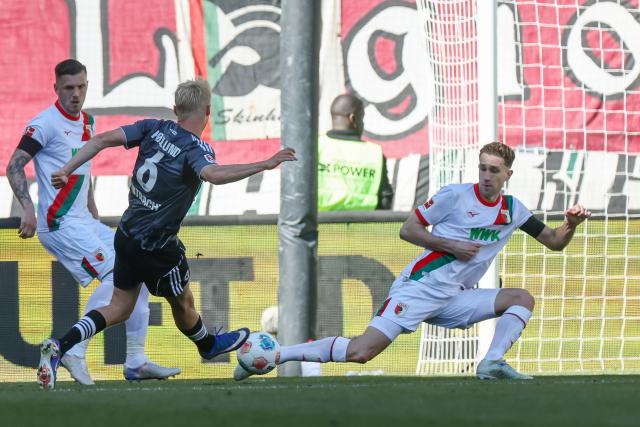 25 April 2026, Bavaria, Augsburg: Frankfurt's Oscar Hoejlund (L) and Augsburg's Arthur Chaves battle for the ball during the German Bundesliga soccer match between FC Augsburg and Eintracht Frankfurt at WWK-Arena. Photo: Daniel Löb/dpa - WICHTIGER HINWEIS: Gemäß den Vorgaben der DFL Deutsche Fußball Liga bzw. des DFB Deutscher Fußball-Bund ist es untersagt, in dem Stadion und/oder vom Spiel angefertigte Fotoaufnahmen in Form von Sequenzbildern und/oder videoähnlichen Fotostrecken zu verwerten bzw. verwerten zu lassen.