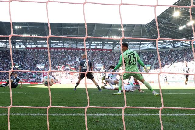 25 April 2026, Bavaria, Augsburg: Augsburg's Anton Kade (R) scores his side's first goal of the game during the German Bundesliga soccer match between FC Augsburg and Eintracht Frankfurt at WWK-Arena. Photo: Daniel Löb/dpa - WICHTIGER HINWEIS: Gemäß den Vorgaben der DFL Deutsche Fußball Liga bzw. des DFB Deutscher Fußball-Bund ist es untersagt, in dem Stadion und/oder vom Spiel angefertigte Fotoaufnahmen in Form von Sequenzbildern und/oder videoähnlichen Fotostrecken zu verwerten bzw. verwerten zu lassen.