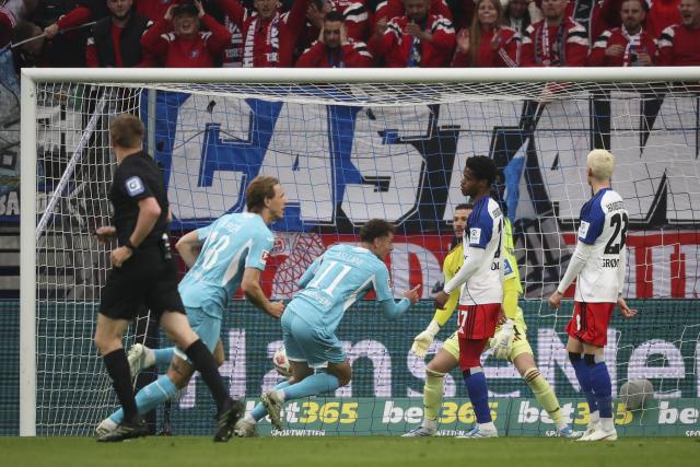 25 April 2026, Hamburg: Hoffenheim's Fisnik Asllani (C) scores his side's first goal of the game during the German Bundesliga soccer match between Hamburger SV and TSG 1899 Hoffenheim at Volksparkstadion. Photo: Christian Charisius/dpa - IMPORTANT NOTICE: DFL and DFB regulations prohibit any use of photographs as image sequences and/or quasi-video.