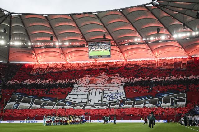 25 April 2026, Hamburg: HSV fans in the North Stand celebrate their team with a choreographed display and pyrotechnics during the German Bundesliga soccer match between Hamburger SV and TSG 1899 Hoffenheim at Volksparkstadion. Photo: Christian Charisius/dpa - IMPORTANT NOTICE: DFL and DFB regulations prohibit any use of photographs as image sequences and/or quasi-video.