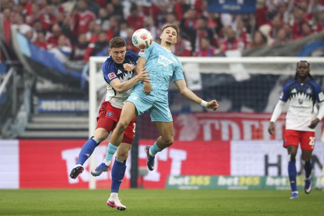 25 April 2026, Hamburg: Hamburger's Nicolai Remberg (C) and Hoffenheim's Tim Lemperle battle for the ball during the German Bundesliga soccer match between Hamburger SV and TSG 1899 Hoffenheim at Volksparkstadion. Photo: Christian Charisius/dpa - IMPORTANT NOTICE: DFL and DFB regulations prohibit any use of photographs as image sequences and/or quasi-video.