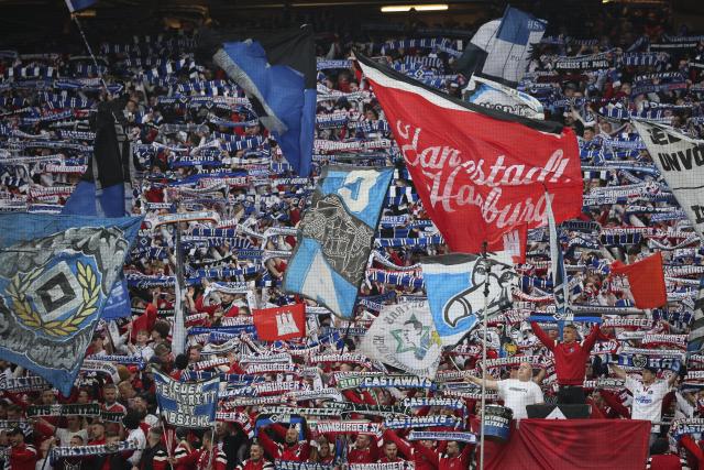 25 April 2026, Hamburg: HSV fans in the North Stand celebrate their team with a choreographed display and pyrotechnics during the German Bundesliga soccer match between Hamburger SV and TSG 1899 Hoffenheim at Volksparkstadion. Photo: Christian Charisius/dpa - IMPORTANT NOTICE: DFL and DFB regulations prohibit any use of photographs as image sequences and/or quasi-video.