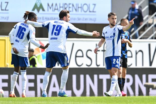 26 April 2026, North Rhine-Westphalia, Paderborn: Schalke's Adil Aouchiche (R) celebrates scoring his side's second goal with teammates Moussa Ndiaye (L) and Kenan Karaman during the German 2nd Bundesliga soccer match between SC Paderborn 07 and FC Schalke 04 at Home Deluxe Arena. Photo: Swen Pförtner/dpa - WICHTIGER HINWEIS: Gemäß den Vorgaben der DFL Deutsche Fußball Liga bzw. des DFB Deutscher Fußball-Bund ist es untersagt, in dem Stadion und/oder vom Spiel angefertigte Fotoaufnahmen in Form von Sequenzbildern und/oder videoähnlichen Fotostrecken zu verwerten bzw. verwerten zu lassen.
