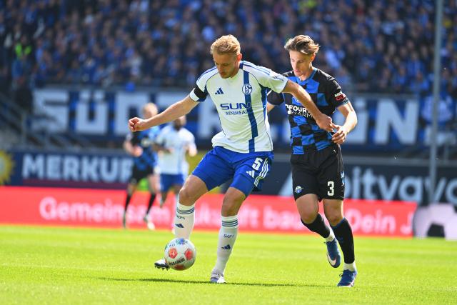 26 April 2026, North Rhine-Westphalia, Paderborn: Schalke's Timo Becker (L) and Paderborn's Jonah Sticker battle for the ball during the German 2nd Bundesliga soccer match between SC Paderborn 07 and FC Schalke 04 at Home Deluxe Arena. Photo: Swen Pförtner/dpa - WICHTIGER HINWEIS: Gemäß den Vorgaben der DFL Deutsche Fußball Liga bzw. des DFB Deutscher Fußball-Bund ist es untersagt, in dem Stadion und/oder vom Spiel angefertigte Fotoaufnahmen in Form von Sequenzbildern und/oder videoähnlichen Fotostrecken zu verwerten bzw. verwerten zu lassen.