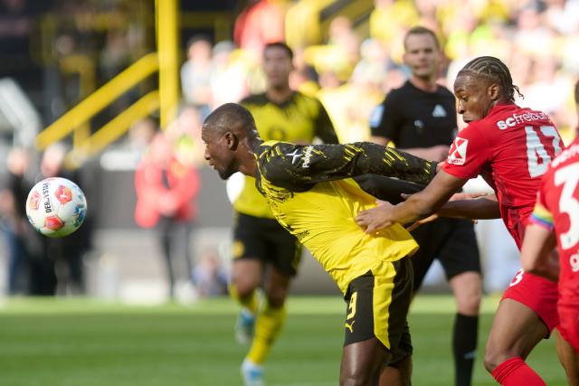 26 April 2026, North Rhine-Westphalia, Dortmund: Borussia Dortmund's Serhou Guirassy (L) and Freiburg's Bruno Ogbus battle for the ball during the German Bundesliga soccer match between Borussia Dortmund and SC Freiburg at Signal Iduna Park. Photo: Bernd Thissen/dpa - WICHTIGER HINWEIS: Gemäß den Vorgaben der DFL Deutsche Fußball Liga bzw. des DFB Deutscher Fußball-Bund ist es untersagt, in dem Stadion und/oder vom Spiel angefertigte Fotoaufnahmen in Form von Sequenzbildern und/oder videoähnlichen Fotostrecken zu verwerten bzw. verwerten zu lassen.