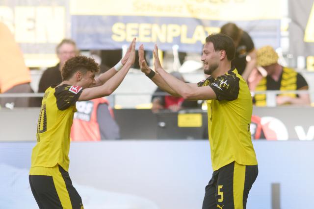 26 April 2026, North Rhine-Westphalia, Dortmund: Borussia Dortmund's Ramy Bensebaini (R) celebrates scoring his side's third goal with teammate Samuele Inacio during the German Bundesliga soccer match between Borussia Dortmund and SC Freiburg at Signal Iduna Park. Photo: Bernd Thissen/dpa - WICHTIGER HINWEIS: Gemäß den Vorgaben der DFL Deutsche Fußball Liga bzw. des DFB Deutscher Fußball-Bund ist es untersagt, in dem Stadion und/oder vom Spiel angefertigte Fotoaufnahmen in Form von Sequenzbildern und/oder videoähnlichen Fotostrecken zu verwerten bzw. verwerten zu lassen.