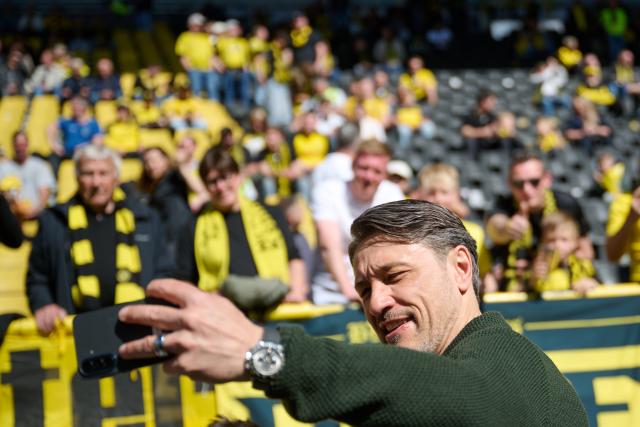 26 April 2026, North Rhine-Westphalia, Dortmund: Borussia Dortmund coach Niko Kovac takes a selfie using a young fan's smartphone during the German Bundesliga soccer match between Borussia Dortmund and SC Freiburg at Signal Iduna Park. Photo: Bernd Thissen/dpa - WICHTIGER HINWEIS: Gemäß den Vorgaben der DFL Deutsche Fußball Liga bzw. des DFB Deutscher Fußball-Bund ist es untersagt, in dem Stadion und/oder vom Spiel angefertigte Fotoaufnahmen in Form von Sequenzbildern und/oder videoähnlichen Fotostrecken zu verwerten bzw. verwerten zu lassen.