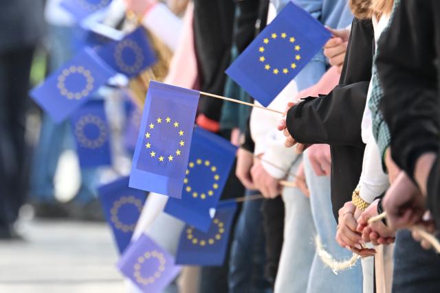 27 April 2026, North Rhine-Westphalia, Marsberg: Pupils from Carolus-Magnus-Gymnasium hold European flags while waiting for the arrival of Chancellor Merz. Merz takes part in a panel discussion with the pupils on European issues. Photo: Federico Gambarini/dpa