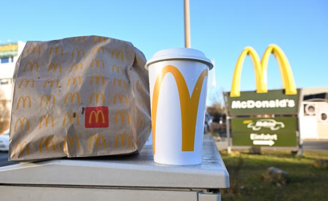 PRODUCTION - 21 January 2025, Baden-Wuerttemberg, Karlsruhe: A McDonald's takeout bag and a takeout cup are sitting in front of a McDonald's restaurant in Tuebingen. Photo: Bernd Weißbrod/dpa