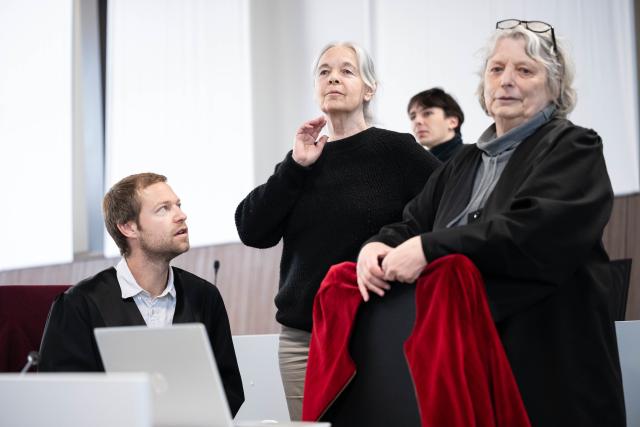 28 April 2026, Lower Saxony, Verden: The defendant Daniela Klette (C) stands with her lawyers Undine Weyers (R) and Lukas Theune (L) at the beginning of the trial day in the provisional courtroom of the Verden district court in Verden-Eitze. The pleas begin in the trial against former RAF terrorist Klette for robbery. Daniela Klette has been on trial since March 2025. Photo: Sina Schuldt/dpa