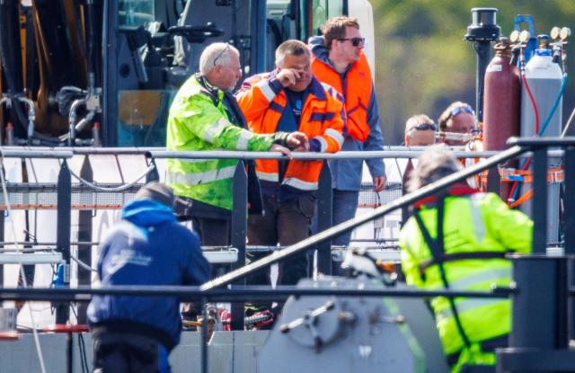 28 April 2026, Mecklenburg-Western Pomerania, Faehrdorf: Diving entrepreneur Fred Babbel (C) celebrates on the transport ship after the stranded humpback whale off the island of Poel was pulled onto the barge using straps. The humpback whale, which stranded near Wismar over three weeks ago, is now to be transported by ship to the North Sea. Photo: Jens Büttner/dpa